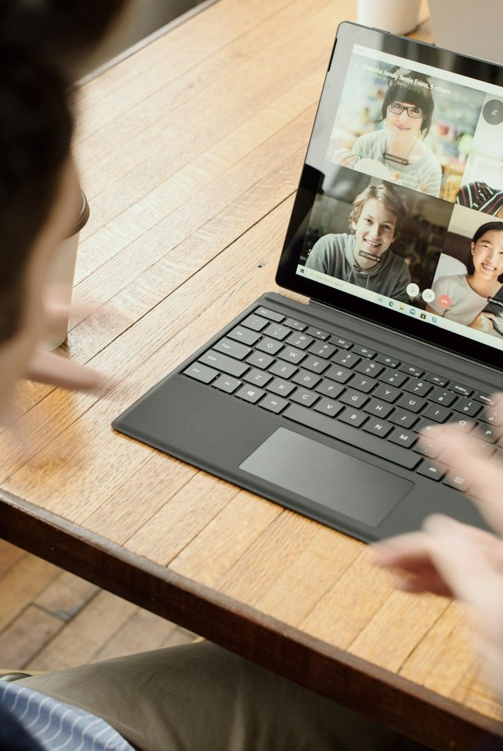 Person attending a video call on a laptop, interacting with multiple participants.